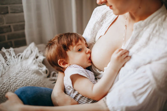 Milchstau in der Stillzeit: Mutter stillt ihr Baby zuhause